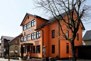 ein orangefarbenes Gebäude mit einem Baum davor in der Unterkunft Konsum Gästehaus Quisisana - Nebenhaus Berghotel Oberhof - nur Übernachtung in Oberhof