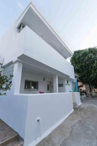 a white building with a white wall at Nikkon summer home in Matala