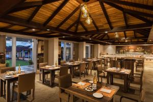 un ristorante con tavoli e sedie in legno e un bar di Fortune Valley View, Manipal - Member ITC's Hotel Group a Manipal