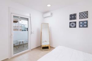 a white bedroom with a mirror and a bed at Nikkon summer home in Matala