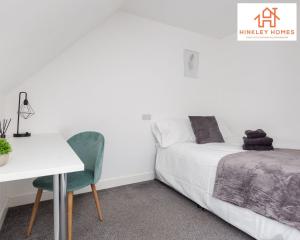 a bedroom with a bed and a white table and chair at Newbuild 4bed - City Centre - Free secure parking! By Hinkley Homes Short Lets & Serviced Accommodation in Liverpool