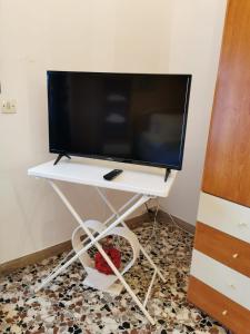 a tv on a white stand with a monitor on it at La Casa di Jennifer in Parma