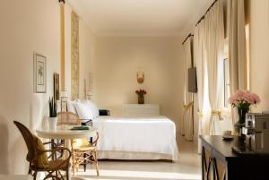a bedroom with a white bed and a table and chairs at Mezzatorre Hotel & Thermal Spa in Forio d'Ischia +48 photos