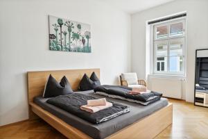 um quarto com 2 camas e uma cadeira em Arbio Apartments near Mariahilferstraße em Viena