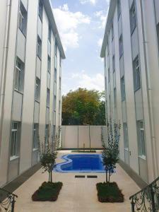 a courtyard with a swimming pool between two buildings at Reikartz Xon Tashkent in Tashkent