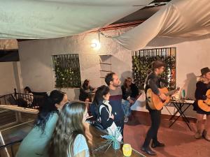 un gruppo di persone che si mettono in piedi in una stanza a suonare di San Isidoro Hostel Sevilla a Siviglia