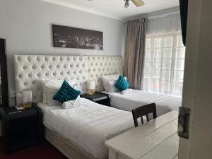 Habitación de hotel con 2 camas y almohadas azules en amazing grace guesthouse en East London