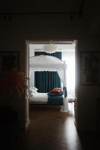 1 dormitorio con 1 cama con dosel blanco en Mola Mola Apart Hotel en Leópolis