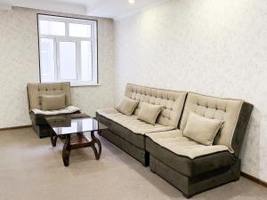 a living room with two couches and a table at Reikartz Xon Tashkent in Tashkent