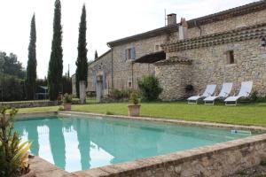a swimming pool in front of a stone house at Studio Indépendant Drôme Provençale in Puygiron
