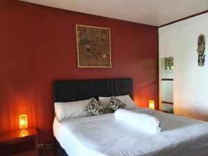 a bedroom with a white bed with red walls at Amban Beach House in Manokwari +30 photos