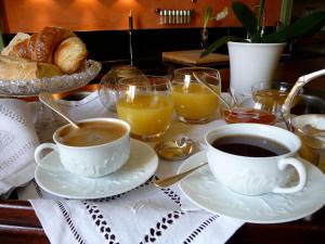 a table with two cups of coffee and a basket of bread at La Grande Maison in Seine-Port