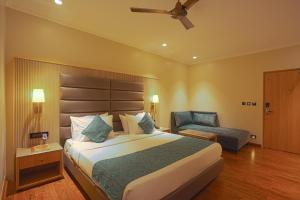 1 dormitorio con 1 cama grande y 1 silla en The Cindrella Hotel en Siliguri