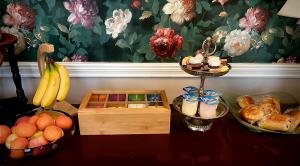 a table topped with bowls of fruit and a basket of bread at Ashleigh House in Carlisle