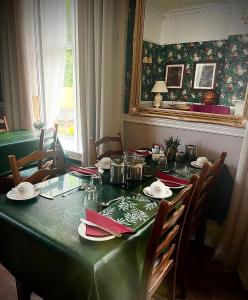 mesa de comedor con mantel verde en Ashleigh House, en Carlisle