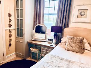 a bedroom with a bed and a tv on a desk at Ashleigh House in Carlisle