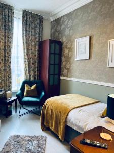 a bedroom with a bed and a chair in it at Ashleigh House in Carlisle