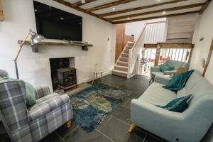 a living room with two couches and a fireplace at Quinta Cottage in Soutergate