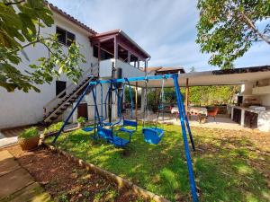 a swing set in the yard of a house at Apartments Vilim in Pinezici