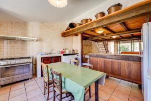 een keuken met een tafel en een fornuis top oven bij Maison de 3 chambres avec piscine partagee terrasse amenagee et wifi a Lagrasse in Lagrasse