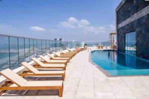 a row of lounge chairs next to a swimming pool at Cartagena Palmetto Beach Bella Vista in Cartagena de Indias