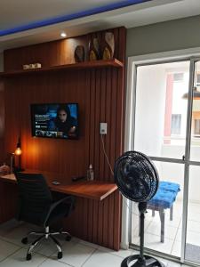 an office with a desk and a chair and a tv at 01 APTO em frete ao Shopping Pátio Norte in São-José-do-Ribamar