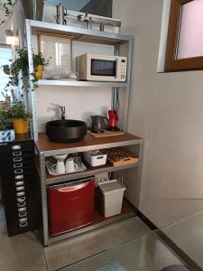 une cuisine avec une étagère et un four micro-ondes. dans l'établissement Loft, parking privé, terrasse, entrée indépendante, à Liège