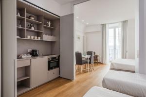 a room with two beds and a kitchen with a table at RG7 Apartments in Catania