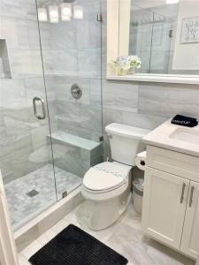 a white bathroom with a toilet and a shower at Downtown! 24h Concierge! Private Balcony! Highrise Views in Atlanta
