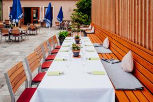 einen langen Tisch in einem Restaurant mit Stühlen und Sonnenschirmen in der Unterkunft Gasthof Linden & Wildkräuterhotel in Windelsbach