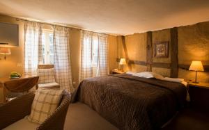 a bedroom with a bed and a table and a chair at Hôtel le Moulin in Gundershoffen