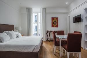 een slaapkamer met een bed en een tafel en stoelen bij RG7 Apartments in Catania