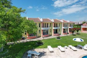 un bâtiment avec des chaises et des parasols dans une cour dans l'établissement Villa Valentina, à Kranevo