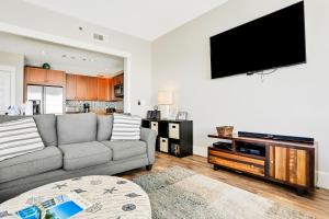 a living room with a couch and a flat screen tv at Redfish Village M1-407 in Santa Rosa Beach