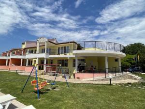 uma casa grande com um parque infantil em frente em Villa Valentina em Kranevo