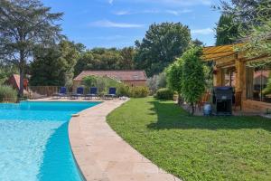 a backyard with a swimming pool and a house at Beautiful guest house for two people on the bank of the Dordogne river in Siorac-en-Périgord