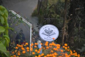 a sign for a garden with orange flowers at 11 Monteviot: Luxury homestay overlooking a tea estate in Kurseong