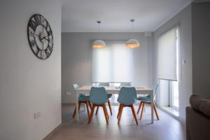 een eetkamer met een tafel en vier stoelen bij The Three Trees Apartments in Sliema