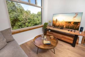 a living room with a large flat screen tv at צמרות האלונים - צימר קסום לזוגות מיוחדים in Tsiv'on