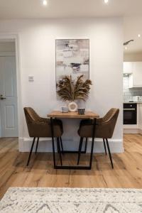 uma mesa de jantar com duas cadeiras numa cozinha em The City Escape - 5* stay in the heart of Glasgow! em Glasgow