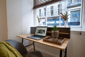 グラスゴーにあるThe City Escape - 5* stay in the heart of Glasgow!の窓の横の机の上に置かれたノートパソコン