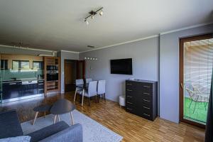 a living room with a couch and a table and a kitchen at Park View Apartman with private garage and balcony in Prague