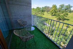 two chairs and a table on a balcony at Park View Apartman with private garage and balcony in Prague