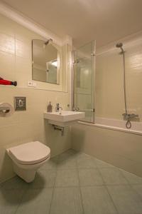 a bathroom with a toilet and a sink and a shower at Park View Apartman with private garage and balcony in Prague