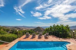 einen Pool mit Stühlen und Bergblick in der Unterkunft La Casa de Alejandro in El Chorro