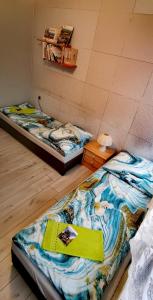 two beds in a room with a book on it at APARTAMENT MILKA w Dusznikach Zdroju in Duszniki Zdrój
