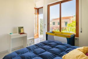 a bedroom with a blue bed and a large window at La Pomelia di Giò in Mondello