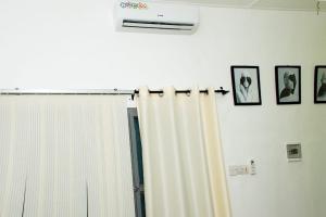 a window with a curtain and some pictures on the wall at GP HOUSES in Cotonou