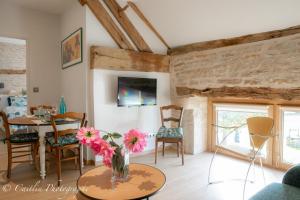 uma sala de estar com uma mesa com flores num vaso em Chez Agnès em Chailly-sur-Armançon