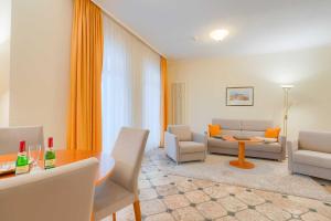 ein Wohnzimmer mit Tisch und Stühlen in der Unterkunft Villa Seestern Whg. 760 in Binz
